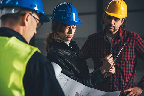 Federal workers in hard hats on a job site.