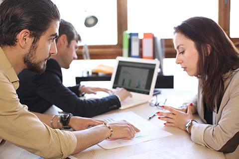 Two people reviewing job listings together at a computer.